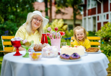 Tyttö ja mummo herkkupöydässä.